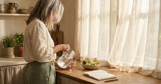 Woman refilling a water glass on a warm summer morning — Desert Harvest bladder comfort