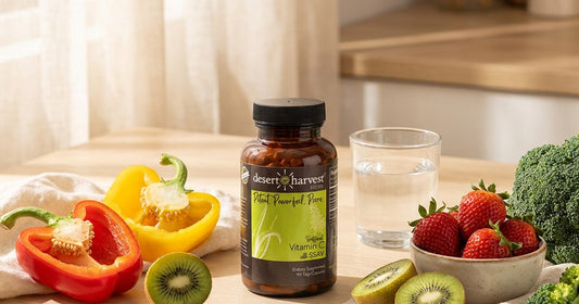 Bell peppers, kiwi and strawberries beside a glass of water on a bright counter — Desert Harvest