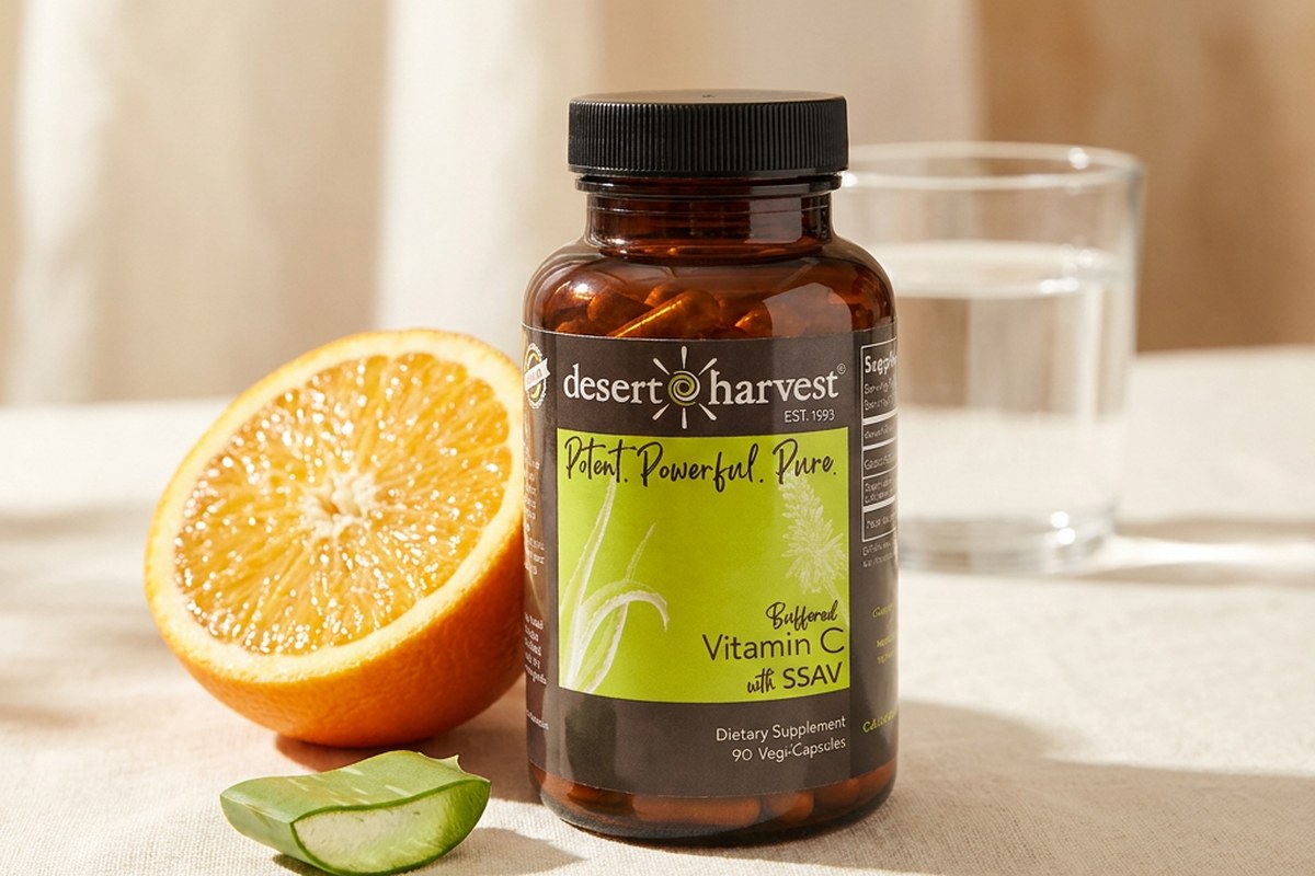 Desert Harvest Buffered Vitamin C bottle with citrus and Aloe Vera on a warm surface