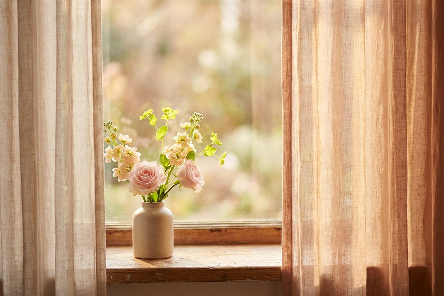 Flowers in a vase on a sunlit windowsill